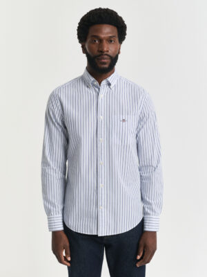 Man wearing a striped blue and white Gant shirt looking at the camera