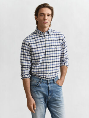 A man looking at the camera wearing a Gant blue checked shirt